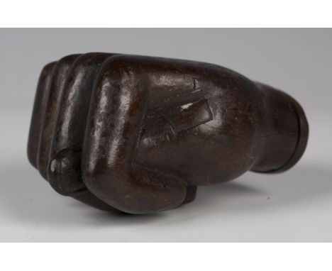 A 19th century carved mahogany novelty snuff box, modelled as a clenched fist, the removable lid inscribed 'Maes', length 8.5