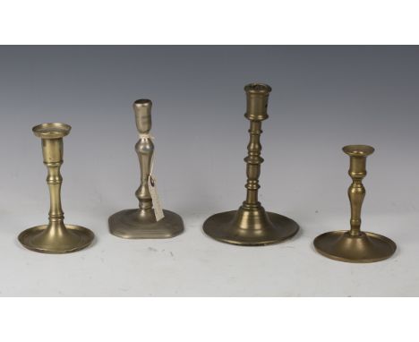 An 18th century candlestick, possibly Paktong, height 16cm, together with three Dutch brass candlesticks, 17th century, all w
