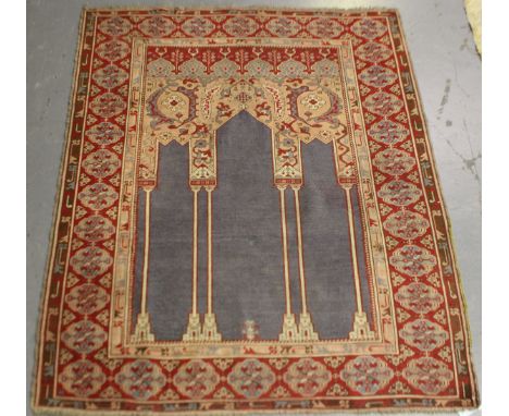 A West Anatolian prayer rug, 19th century, the blue mihrab with four architectural columns, within a red shaped gul border, 1