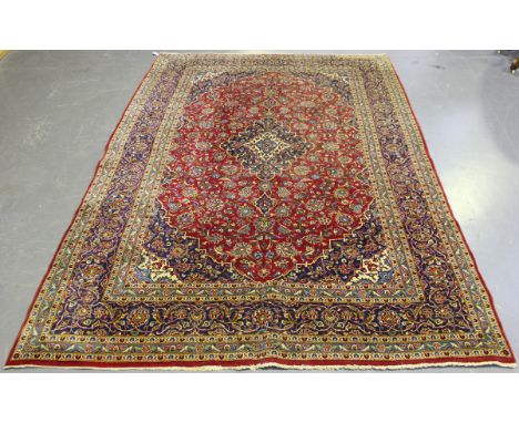 A Kashan carpet, Central Persia, mid-20th century, the claret field with a shaped medallion, profusely supported by foliage w