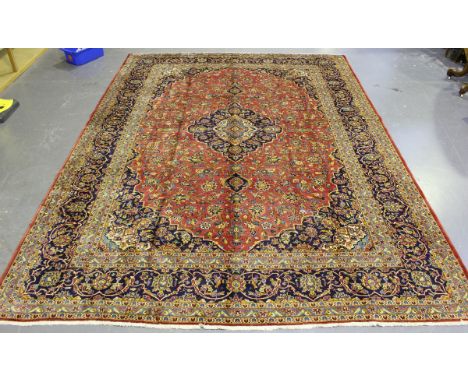 A Kashan carpet, Central Persia, mid/late 20th century, the pink field with a shaped medallion, within a midnight blue border