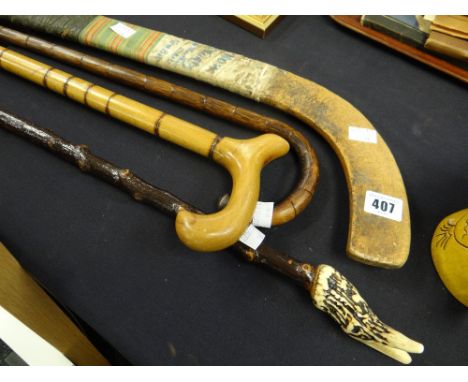 A vintage Indian made hockey stick with stamp marks together with a walking cane, having a silver terminal and two other walk