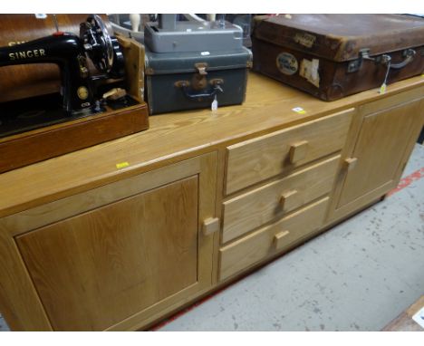 A modern light oak sideboard with three drawers flanked by cupboards Condition reports provided on request by email for this 
