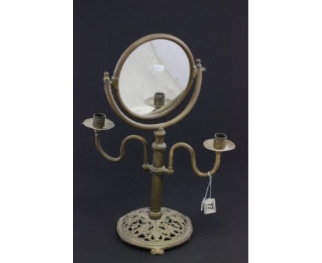 A brass free standing mirror and candlestick