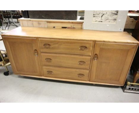 Ercol Light Elm Sideboard with bank of three drawers flanked either side by cupboards