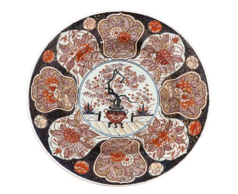 Floral decor on border with scene of flowers in planter in center of charger, 56 cm. in diameter.