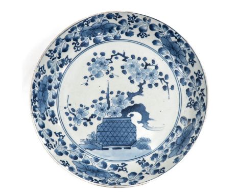 Depicting scene in garden with flowers in planter and floral border, 30 cm. in diameter. 