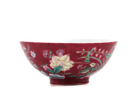 Ruby ground decorated with flowers in Famille Rose enamels, Qianlong mark, 10 cm in diameter. 