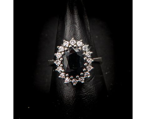 Set with 16 brilliant cut diamonds and 1 sapphire, approximately 6 x 9 mm., ring size 17.