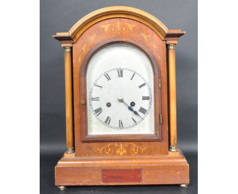 An early 20th century Edwardian inlaid 8 day mantle clock having an arch top mantel clock with engraved silvered face and Rom