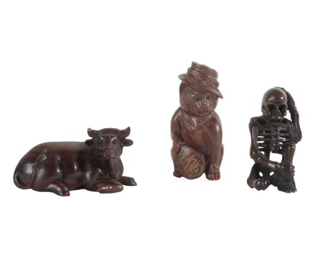 THREE JAPANESE NETSUKE including an example modelled as a water buffalo, signed 6cm long, a skeleton, 5.5cm high, and a cat i