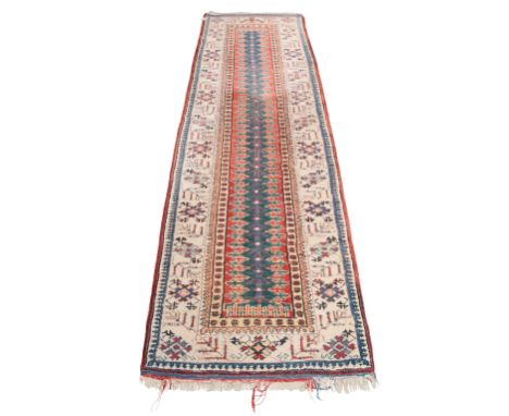 A SERAB STYLE RUNNER woven in blue and red with central pole medallion on a green ground (faded to blue to pile), within pale