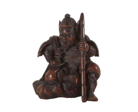 A JAPANESE CARVED WOOD NETSUKE probably Edo period, 19th century, in the form of a warrior with staff and armour, signed to t