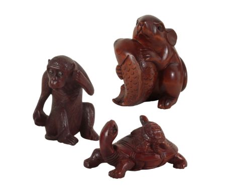 A GROUP OF THREE CARVED WOOD NETSUKE including a Meiji period figured monkey, with inlaid eyes, 5cm high, and two others, the