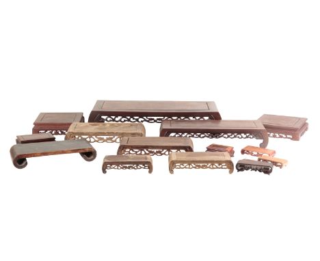 A GROUP OF FIFTEEN CHINESE WOODEN STANDS each in varying scroll table form, the largest 12cm high x 62cm wide, the smallest 1