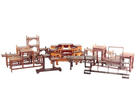 A GROUP OF NINE CHINESE WOODEN STANDS each of architectural design, the tallest measures 30cm high x 34cm wide, the smallest 