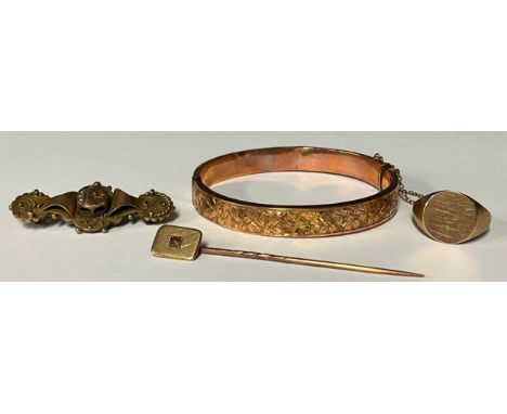 A 9ct rose gold hinged bangle, engraved with trailing ivy, marked 375, safety chain, Birmingham 1919, 7.9g; a 9ct gold signet