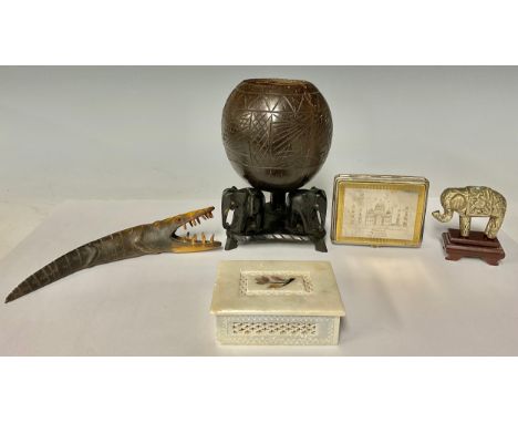 An Indian elephant coconut cup, tripod feet, 19cm high; a mother of pearl inlaid alabaster box; a Taj cigarette case; a silve