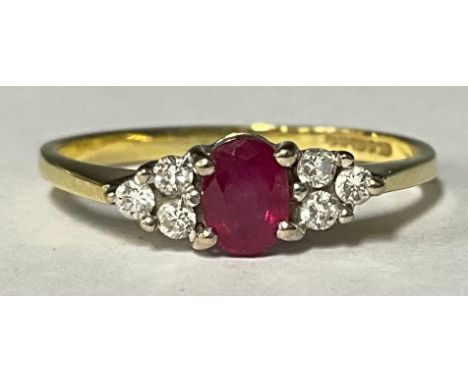 An 18ct gold ring, the central oval cut ruby flanked by three diamonds to either shoulder, size P, Birmingham 1992, 2g, boxed