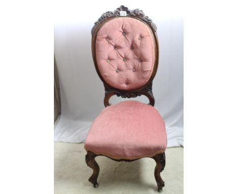A very fine antique walnut lady's parlour chair; oval button back with carved surmount, carved cabriole legs 