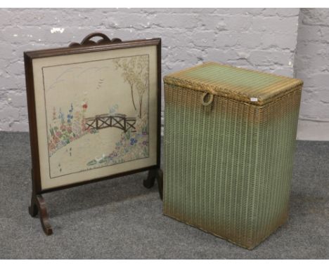 An oak firescreen with needlework panel, along with a painted green linen basket.