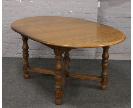 An Ercol Golden Dawn oval extending dining table with inbuilt leaf raised on turned square legs, 212cm long when extended x 1