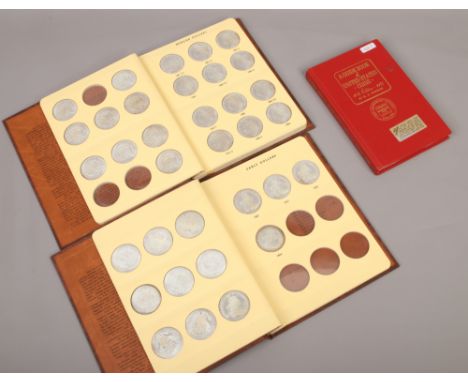 Two folders of reproduction US dollars to include Morgan and Early, along with a guide book of United States Coins.