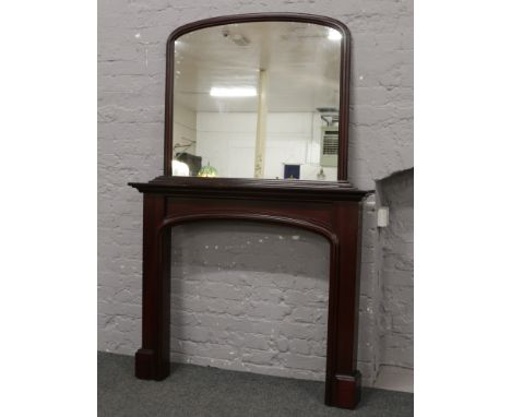 A dark stained mahogany fire surround and over mantle mirror.