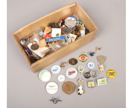 A box of badges to include brass and enamel examples.