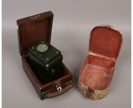 A cased pigeon racing clock along with a vintage first aid tin.