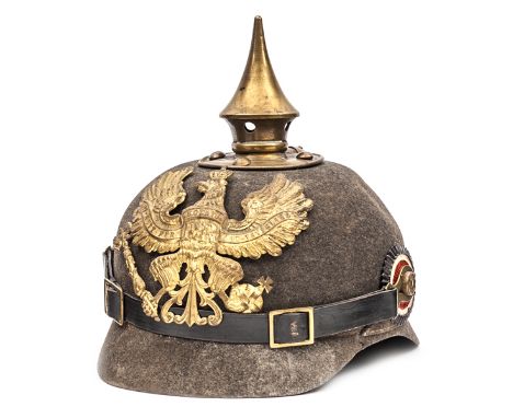 A Prussian ersatz felt pickelhaube, the one piece skull with brass line eagle badge, spike, and rear rib, and with national r