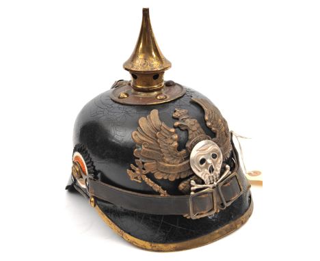 A German pickelhaube, the leather skull with brass fittings, the inside with indistinct maker’s stamp, with national and Brun