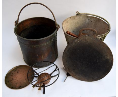 A vintage bucket along with two shallow copper pans and two heavy gauge brass saucepans, and a large riveted copper bucket wi