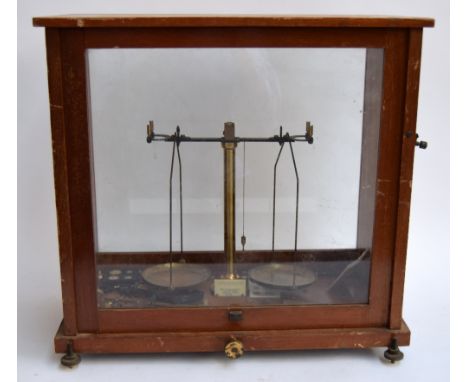 A set of brass laboratory scales by Baird & Tatlock (London) Ltd in a glazed case