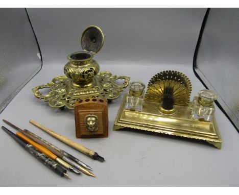 Brass ink wells and pens. One unusual with 2 glass ink wells with brass fittings and pen wipe, the other a heavy brass inkwel