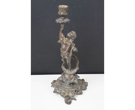 Spelter cast candlestick of winged cherub on foliage base, H 31cm