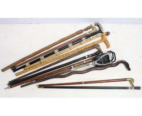 Collection of eleven assorted walking stick canes to include carved snake, intricate carved elephant, brass duck handle, bras