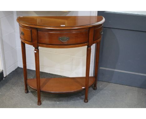 Contemporary demi lune console side table having a three frieze drawers raised on turned legs with under tier shelf. Measures