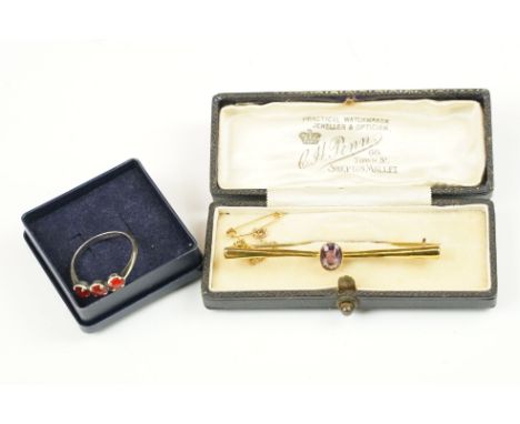 An early 20th century 9ct gold bar brooch set with central amethyst together with a sterling silver three stone ring. 