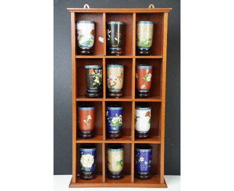 Twelve Chinese ceramic cloisonne cups with floral motifs of Asian inspiration, each with carved wooden base, H 9cm, all house