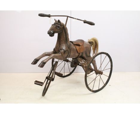 Horse tricycle, with carved wooden horse with tooled leather saddle, with cast iron frame and cast iron and wooden wheels, 85