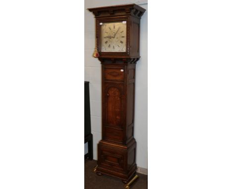 An Edwardian oak carved eight-day long case clock, silver dial signed Maple. London, double weight drive movement, striking o