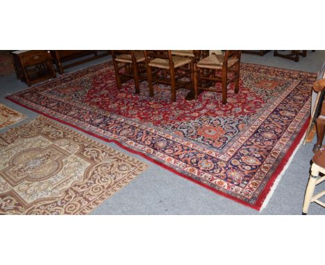 Mashad carpet, the light red field of vines around a medallion, framed by spandrels and indigo borders, 385cm by 247cm 