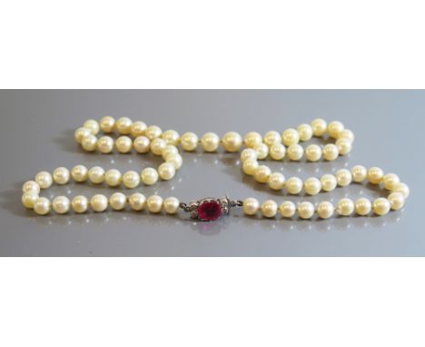 A Single Strand of Pearls with ruby and diamond clasp, 53 cm, largest pearl c. 9 mm