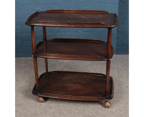 A Ercol three tier dark elm drinks trolley, complete with wheels.  