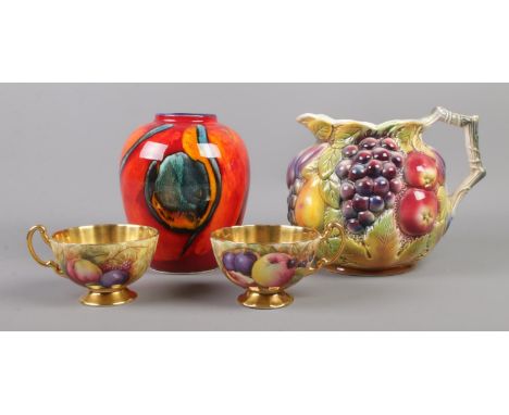 A Poole 'Volcano' vase, together with Sylvac 478 ceramic fruit pitcher and two Aynsley ceramic teacups, decorated with fruit 