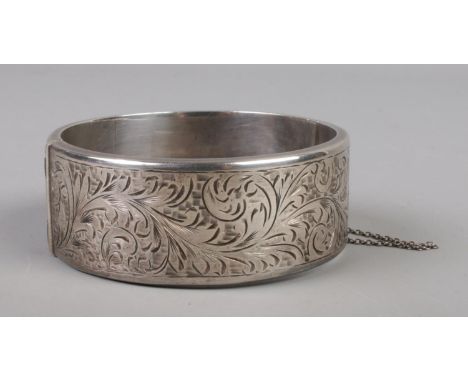A silver bangle with chased decoration. Assayed Chester 1953 by Joseph Smith &amp; Sons Ltd. 42g.  