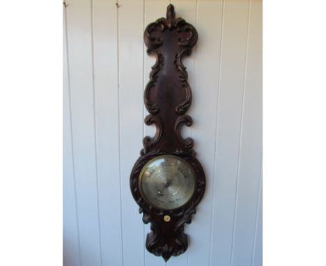 A 19th Century mahogany 10" wheel barometer on ornate carved case, with circular thermometer tube to dial, maker Jones, Gray 