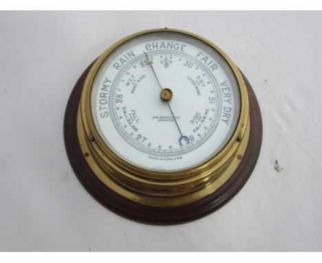 A brass cased ship's aneroid barometer, enamel dial signed John Barker & Co., Ltd, Kensington 