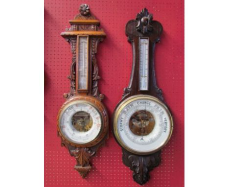 Two oak carved cased aneroid barometers with long thermometer boxes